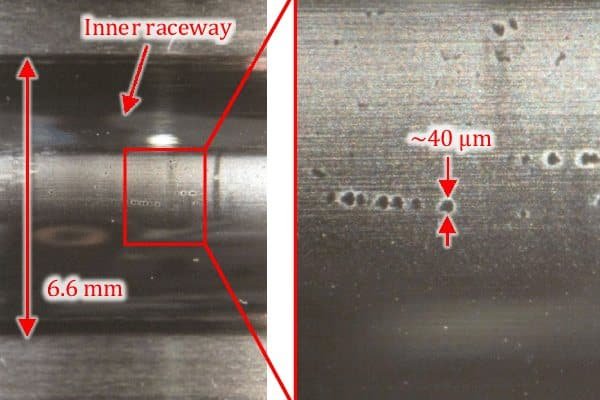 Microscopic view of steel surface showing thousands of tiny, round craters with smooth, melted edges caused by electrical arcing.