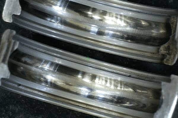 A close-up view of a steel bearing raceway showing the distinct washboard fluting pattern caused by severe electrical erosion.