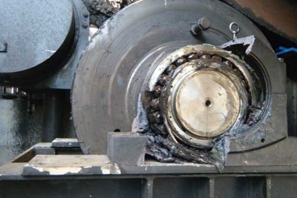 Electrical Lubrication Breakdown: Why Bearing Grease Turns Black Close-up of a failed industrial motor bearing filled with dry, black, carbonized grease sludge caused by electrical discharge.