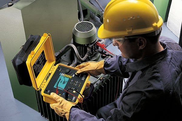 A technician using a Megger insulation tester to check the resistance of an aluminum oxide coated insulated bearing.