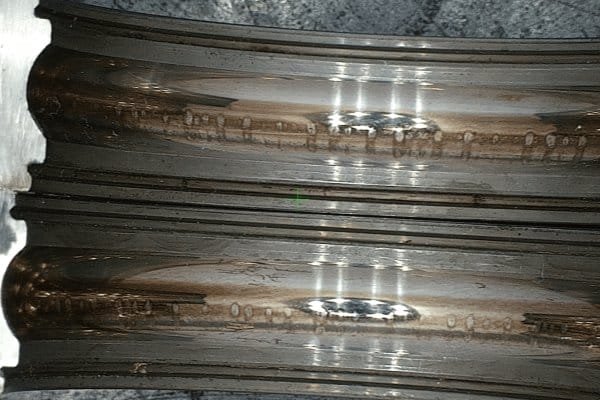 Illustration showing how VFD-generated shaft voltage creates arcs and pitting on standard bearing raceways.